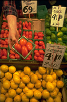 An image of a produce stand, with lemons, limes, and tomatoes for sale